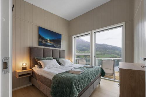 a bedroom with a large bed and a large window at Olden Fjord View in Olden