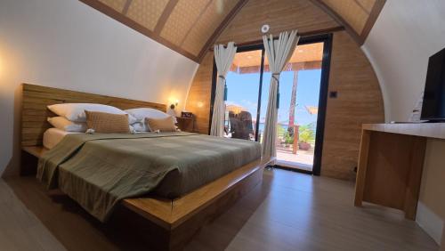 a bedroom with a large bed and a large window at Kubotique Beachfront Staycation in El Nido