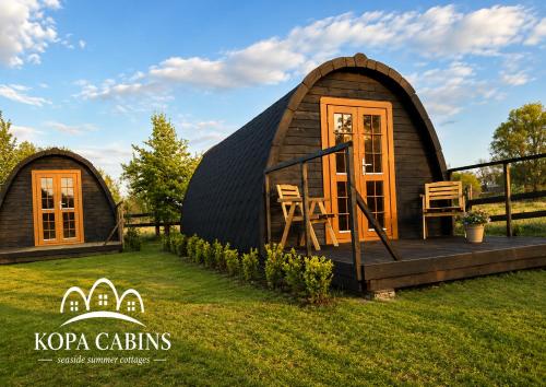 a large dome shaped house on a grass field at KOPA CABINS seaside stay in Nida