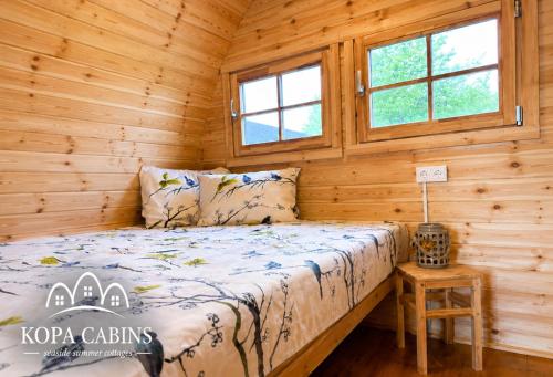 a bedroom with a bed in a log cabin at KOPA CABINS seaside stay in Nida