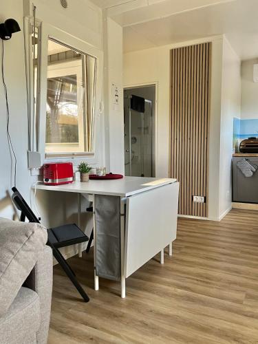 a kitchen and living room with a table and a couch at Tiny house am Wald eingezäunt in Meißendorf