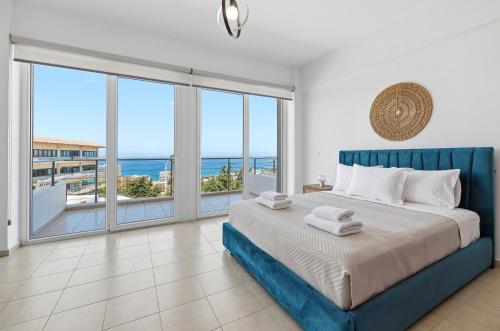a bedroom with a bed with a view of the ocean at Celestial Luxury Residences in Asgourou