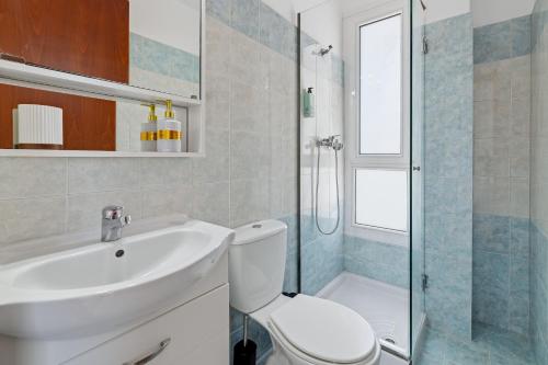a bathroom with a toilet and a sink and a shower at Celestial Luxury Residences in Asgourou