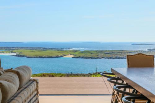 a view of the ocean from the deck of a house at Luxury Glass Villa with Hot Tub & Sea Views - Connemara in Roundstone