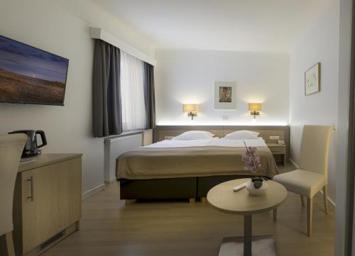 ein Hotelzimmer mit einem Bett und einem Tisch in der Unterkunft Hotel Francais in Luxemburg (Stadt)