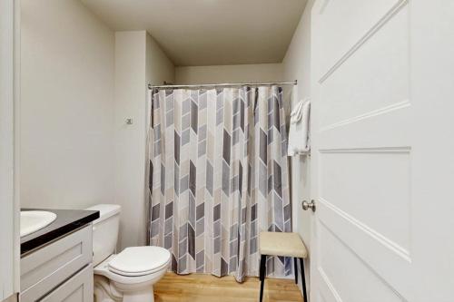 a bathroom with a toilet and a shower curtain at Mod Haus 1 in Kalispell