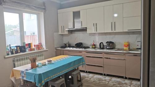 a kitchen with white cabinets and a table in it at Minsu in Mamyr