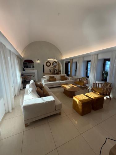 a large living room with couches and tables at Maison Palms in Mesaria