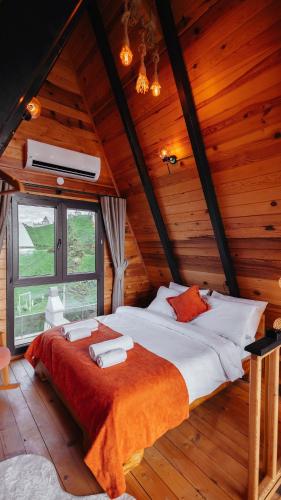 a bedroom with a large bed in a wooden room at Koda Bungalov in Ardeşen
