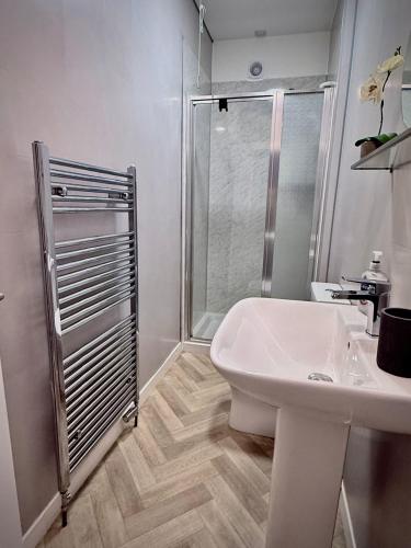 a white bathroom with a shower and a sink at Coorie in Inverness
