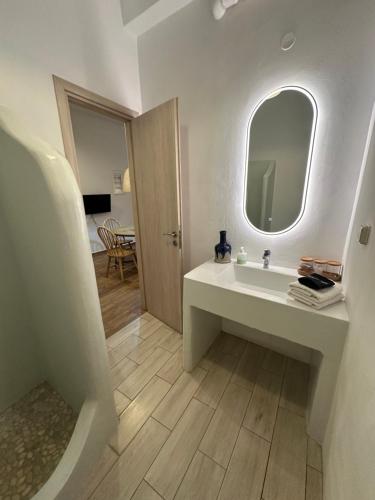 a white bathroom with a sink and a mirror at Apocalypsis Houses in Skala