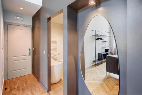 a hallway with a mirror and a bathroom with a sink at San Carlo Suite Torino in Turin