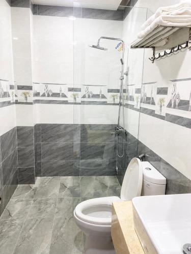a bathroom with a white toilet and a shower at VyVy House Hotel in Tuy Hoa