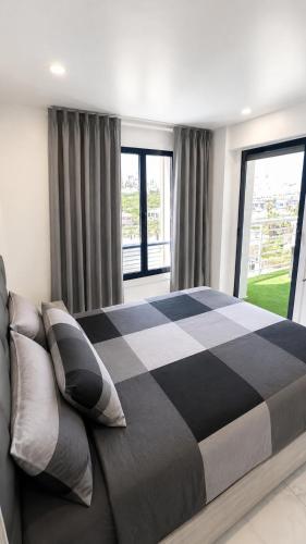 a bedroom with a black and white bed with windows at Torrevieja - La Mata Beach First Line New Apartments 2024r in La Mata