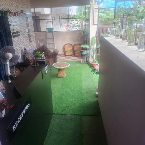 a room with a green floor with a table and chairs at Hotel good vibes in Coimbatore