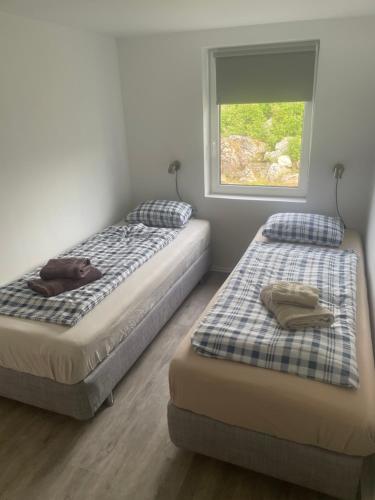 a bedroom with two beds and a window at Apartment Frøya in Sætra