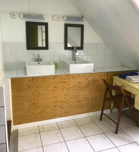 a bathroom with two sinks and two mirrors at Le Rebond in Pommerit-le-Vicomte