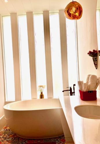 a bath tub in a bathroom with windows at Big Pvt Pool & Garden 3BHK Villa, Morjim Beach 10-14mts in Siolim