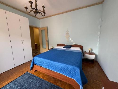 a bedroom with a bed with a blue blanket at Appartamento Iris in Torre Pellice