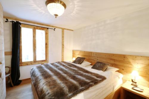 ein Schlafzimmer mit einem großen Bett und einem Fenster in der Unterkunft Apartments Dimlej in St. Moritz