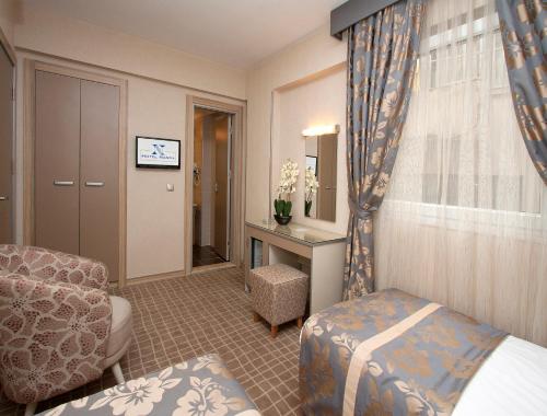 a hotel room with a bed and a chair at Nanda Hotel in Istanbul