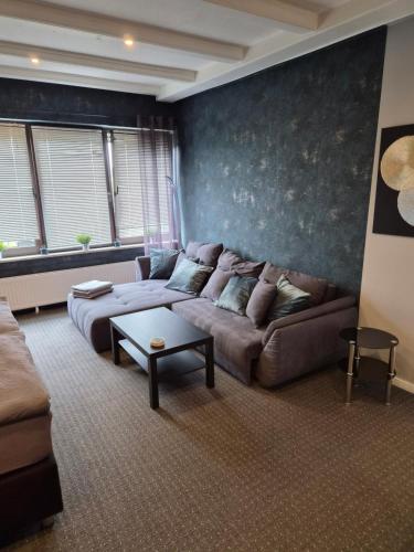 a living room with a couch and a table at Zur schönen Aussicht in Langenfeld