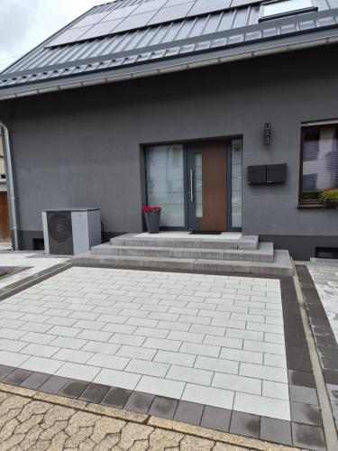 a house with a brick patio in front of it at Zur schönen Aussicht in Langenfeld