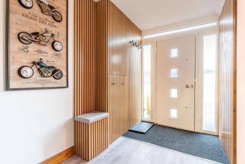 a hallway with a wooden wall with motorcycles on it at Triumph House in Hinckley