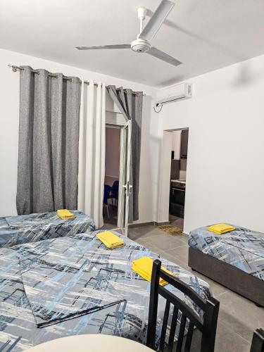 a bedroom with two beds and a ceiling fan at Klea Rooms in Velipojë