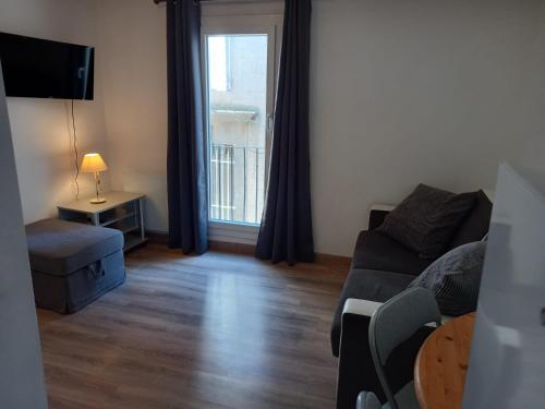 a living room with a couch and a table and a window at Studio UN Hagoort in Agde