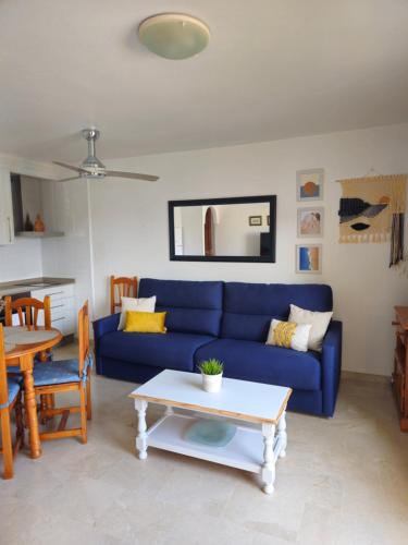 a living room with a blue couch and a table at Casa Indalo Vera Coast in Vera