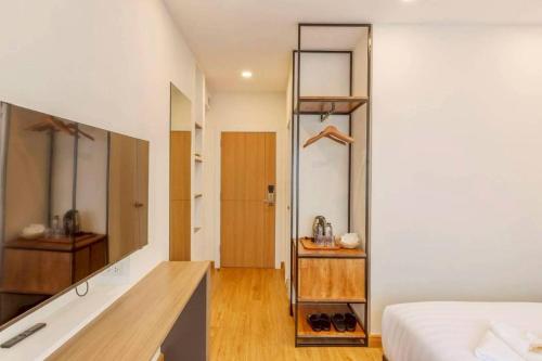 ein Schlafzimmer mit einem Bett und einem Holzschreibtisch in der Unterkunft Believeinn in Bangkok