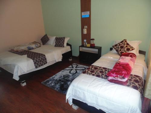 Cette chambre comprend 2 lits et un tapis. dans l'établissement River Fun Beach Resort, à Gorkhā