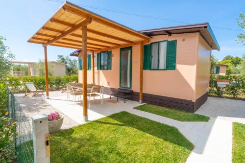 a tiny house with a patio and awning at Agricamping L'Ibisco in Riotorto