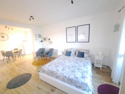 a bedroom with a bed with blue pillows and chairs at Apartman Karmen in Vodice