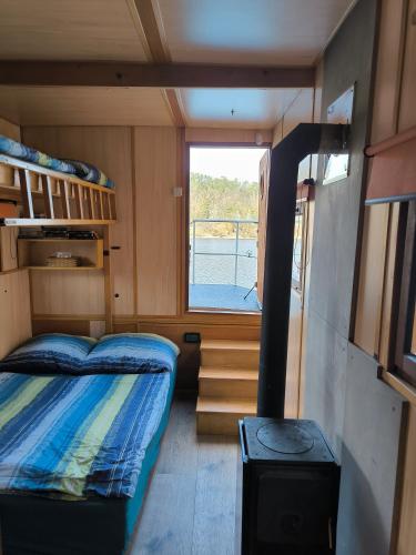 a small room with a bunk bed and a window at Hausbót Slapy in Dublovice