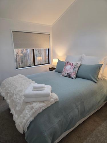 a bedroom with a bed with two towels on it at Changing Seasons in Cambridge