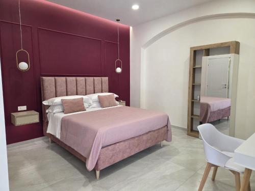 a bedroom with a purple wall and a bed at Suite in centro in Aversa