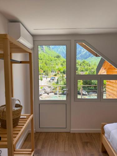 a room with a sliding glass door with a mountain view at Guesthouse Kurora e Maleve in Ndërlysaj