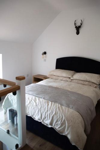 a bedroom with a large bed with a black headboard at The Old Blacksmiths in Bridgnorth