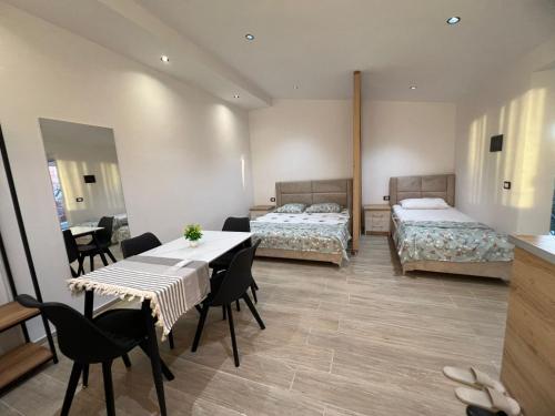 a room with two beds and a table and chairs at Rent Room Albano in Vlorë