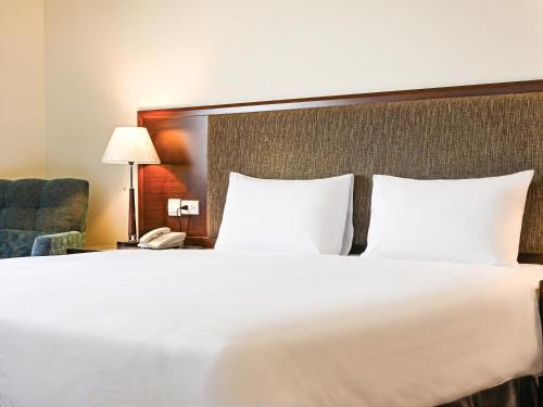 a hotel room with a large bed and a telephone at CHECK inn Taipei Neihu in Taipei