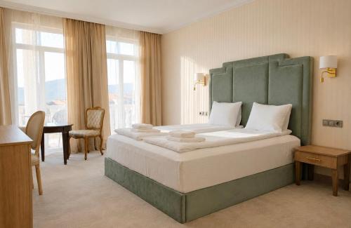 a bedroom with a large bed with a green headboard at Aleksov Complex Sans Souci in Ognyanovo