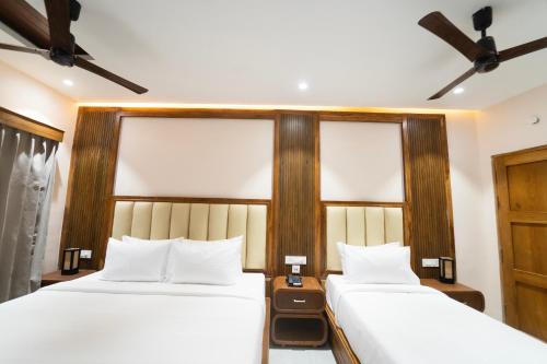 a bedroom with two beds and two windows at PSR Coral Resorts, 800m Away from Rameswaram Temple in Rāmeswaram