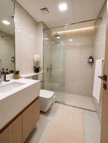 a bathroom with a shower and a toilet and a sink at Inter Home Coral - beach access in Ras al Khaimah