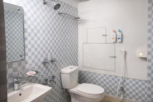 a bathroom with a toilet and a sink and a mirror at Baral White Rose Hotel Dhaka in Dhaka