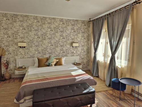a bedroom with a bed and a wall with wallpaper at Casa Alina in Arpaşu de Sus