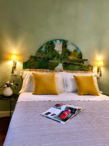 a bedroom with a bed with a magazine on it at Il Sonetto Boutique Apartment - private garage in Mantova