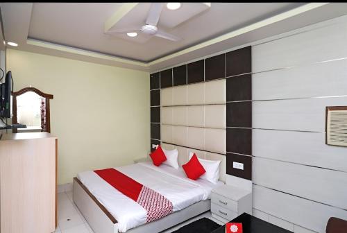 a bedroom with a bed with red pillows at Hotel Neelkanth in Lucknow