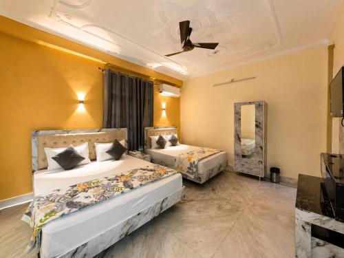 two beds in a hotel room with a mirror at Bhagirathi Residency in Rishīkesh